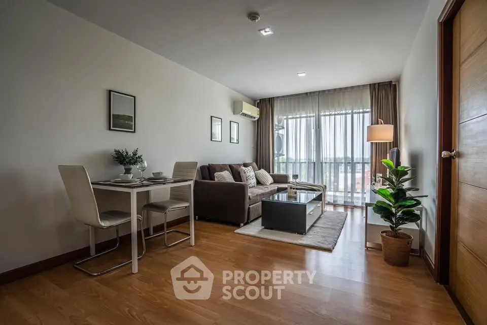 Modern living room with stylish decor and natural light, featuring a cozy sofa and dining area.