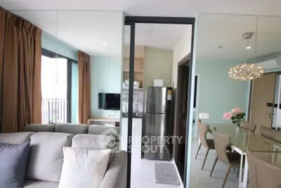 Modern apartment interior with open layout, featuring a cozy living room and sleek kitchen with stainless steel appliances.
