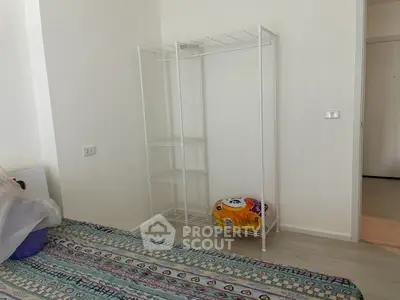 Minimalist bedroom with open wire shelving and colorful bedspread