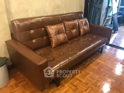 Stylish brown leather sofa in modern living room with parquet flooring