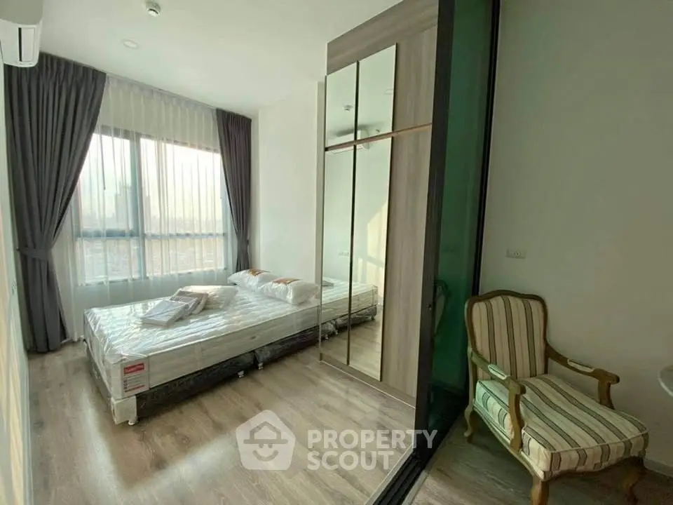 Bright and cozy bedroom with large window and stylish furniture in modern apartment.