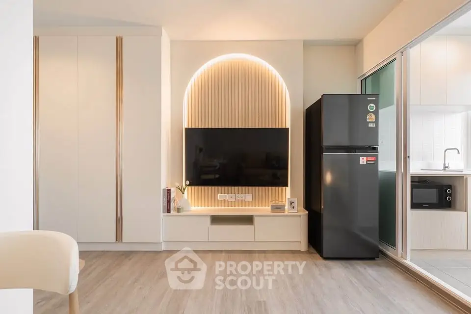 Modern living room with sleek TV setup and stylish kitchen appliances