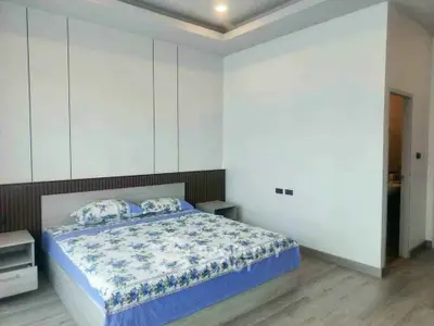Spacious modern bedroom with elegant decor and ample natural light.