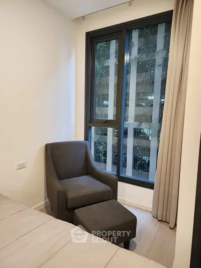 Cozy bedroom corner with armchair and window view in modern apartment