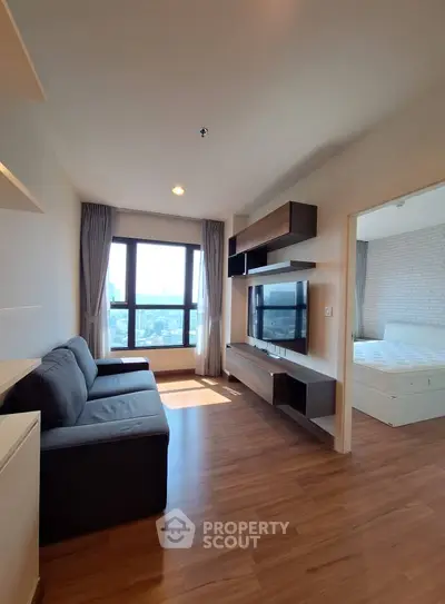Modern living room with city view and stylish furniture in a high-rise apartment.