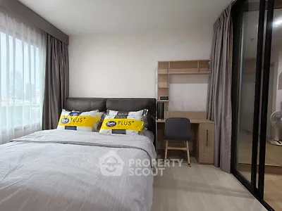Modern bedroom with study area and large window, perfect for urban living.
