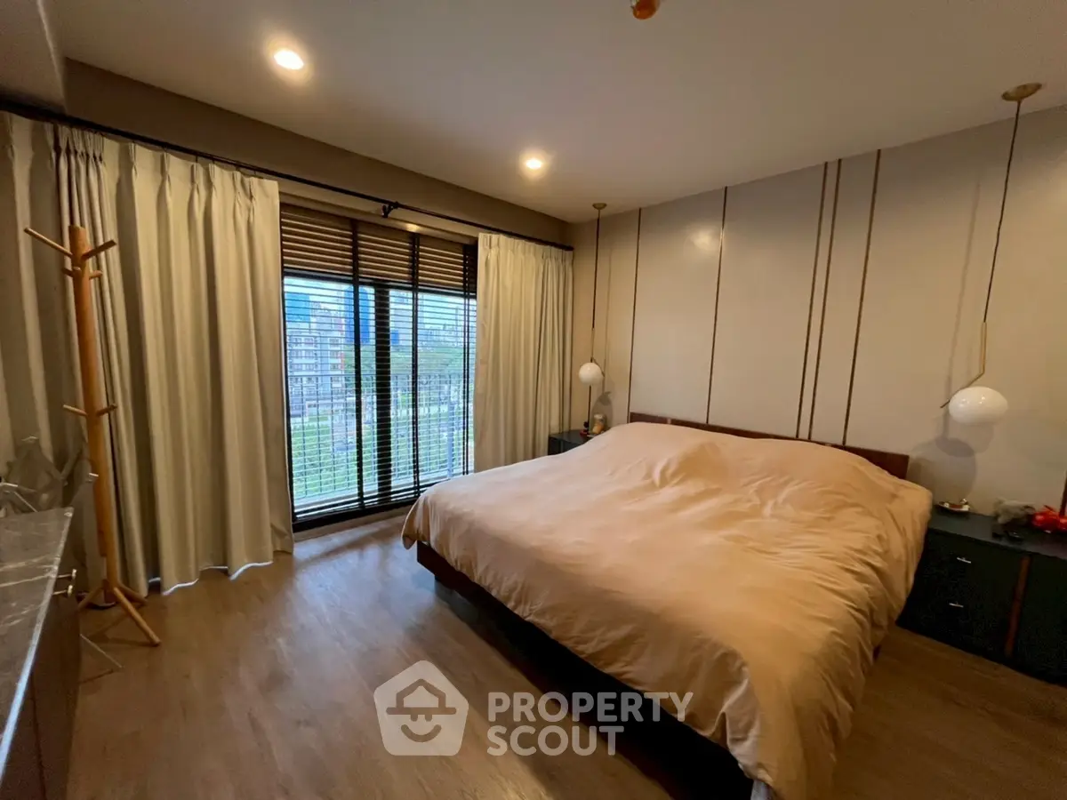 Spacious bedroom with large window and modern decor