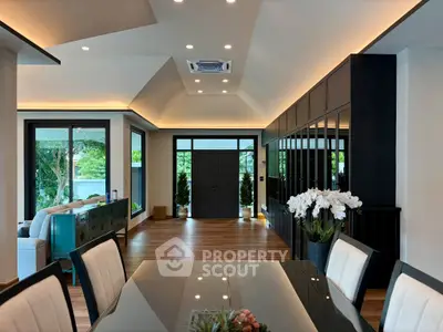 Luxurious open-plan living and dining area with modern decor and garden view.