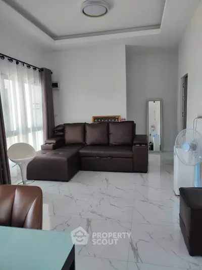 Modern living room with sleek brown leather sofa and elegant marble flooring.