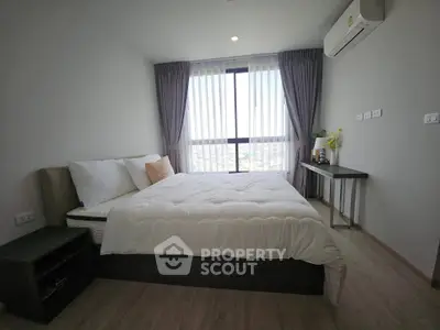 Modern bedroom with large window and stylish decor in a high-rise apartment.