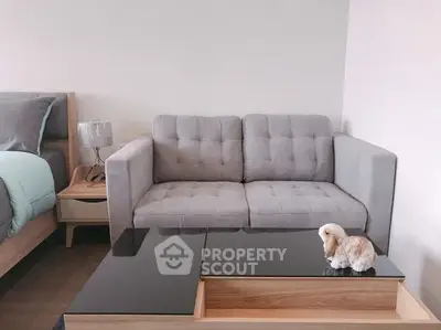 Cozy living room with modern gray sofa and sleek black coffee table, perfect for relaxation.