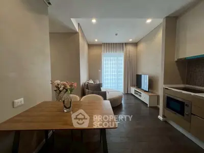 Modern open-plan living room with cozy seating and stylish kitchen area