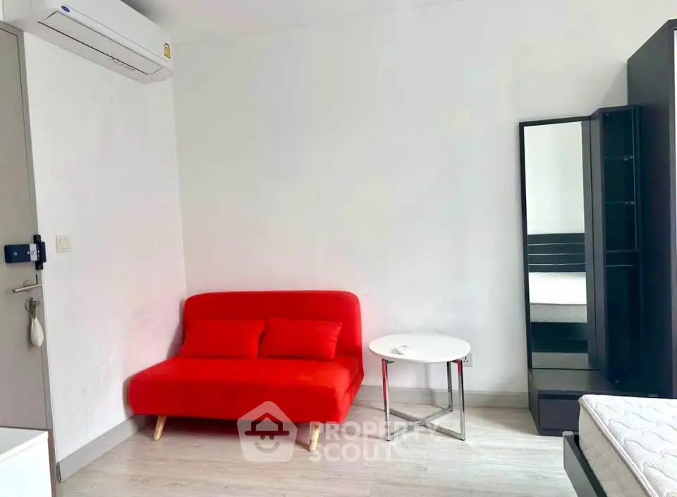 Modern minimalist bedroom with red sofa and sleek furnishings