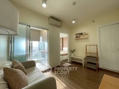 Cozy living room with modern decor and view into a bright bedroom