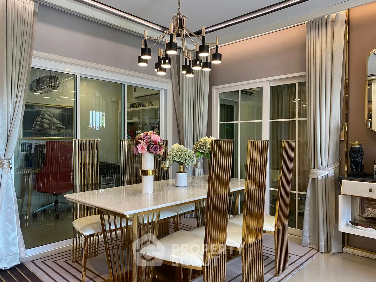Luxurious dining room with elegant chandelier and gold-accented chairs