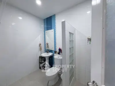 Modern bathroom with sleek white tiles and glass partition
