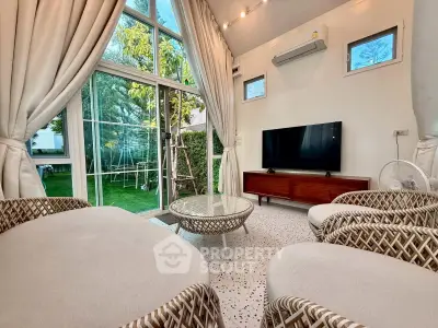 Chic living room with modern decor, large windows, and garden view, perfect for relaxation and entertainment.