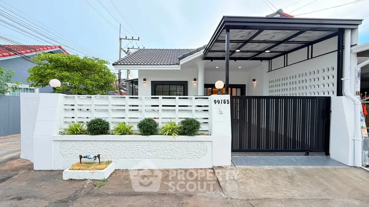 Charming modern house with gated entrance and lush greenery, perfect for family living.