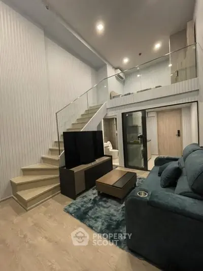 Modern duplex living room with stylish staircase and cozy seating area.