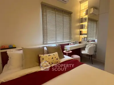 Cozy bedroom with stylish decor and natural light, featuring a comfortable bed and elegant workspace.