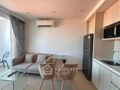 Modern living room with sleek kitchen, featuring cozy sofa, glass table, and stylish chairs, perfect for urban living.