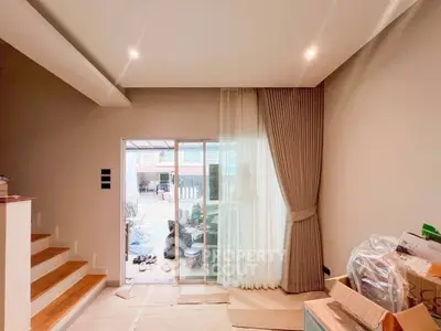 Spacious living room with sliding glass doors and elegant curtains leading to a patio.
