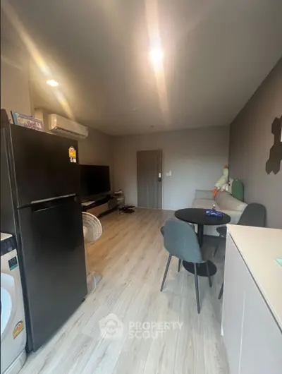 Modern living room with sleek furniture and appliances, featuring a cozy dining area and stylish decor.