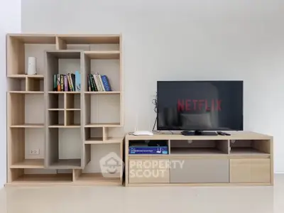 Modern living room with stylish TV stand and bookshelf, perfect for entertainment and relaxation.