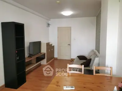 Spacious living room with modern furniture and wooden flooring in a cozy apartment.