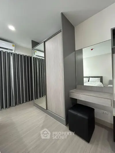 Modern bedroom with sleek wardrobe and vanity, featuring elegant curtains and contemporary design.