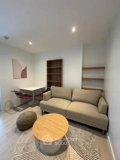 Modern living room with cozy sofa, stylish rug, and elegant dining area in a contemporary apartment.