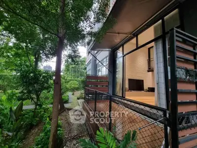 Modern apartment with spacious balcony overlooking lush garden, perfect for nature lovers seeking tranquility.