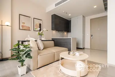 Chic modern living room seamlessly connects to a sleek kitchen, featuring neutral tones, elegant furnishings, and tasteful art, perfect for urban living.