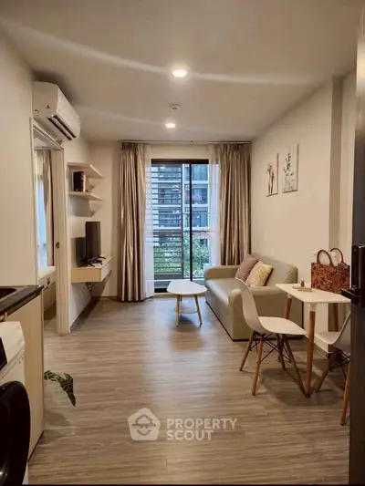 Modern living room with balcony view, stylish furniture, and natural light in urban apartment.
