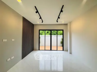 Spacious modern living room with large windows and sleek track lighting