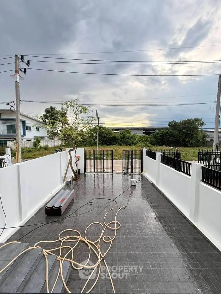 Spacious outdoor terrace with sleek black tiles and modern white fencing, perfect for relaxation and gatherings.