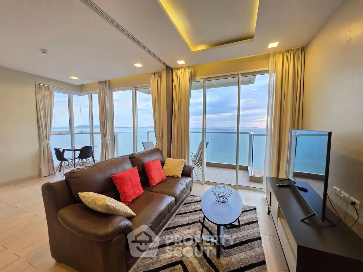 Stunning living room with ocean view and modern decor, featuring a cozy sofa and floor-to-ceiling windows.