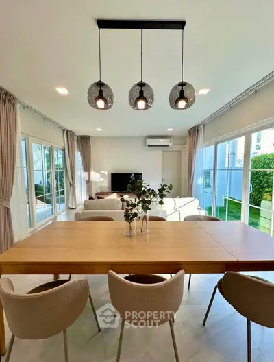 Spacious modern living room with elegant dining area and large windows for natural light.