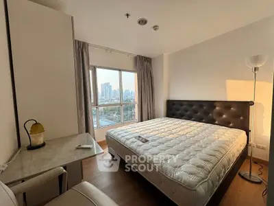 Spacious bedroom with city view, featuring a large bed and elegant decor, perfect for urban living.