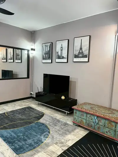 Stylish living room with modern decor and wall art, featuring a sleek TV setup.