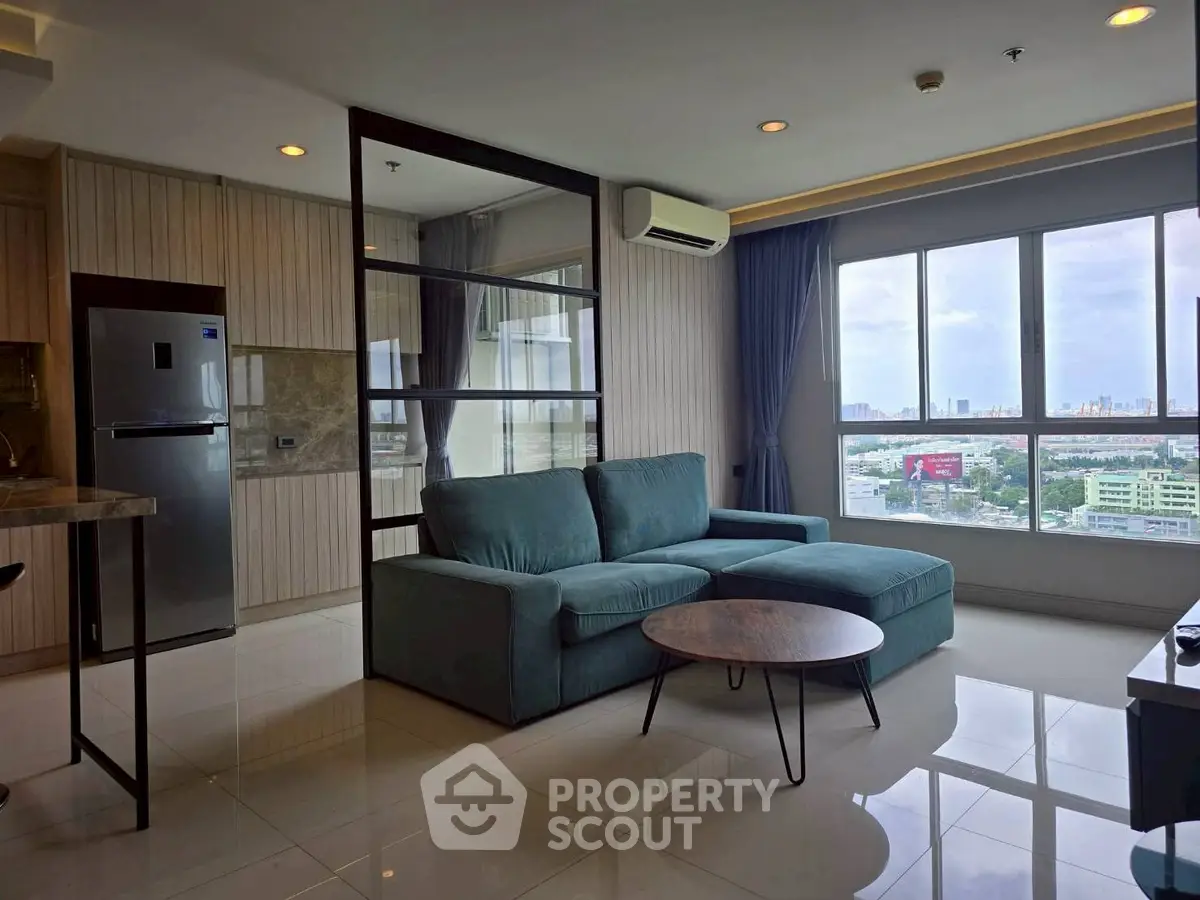 Modern living room with large windows and city view, featuring a stylish sofa and sleek furniture.