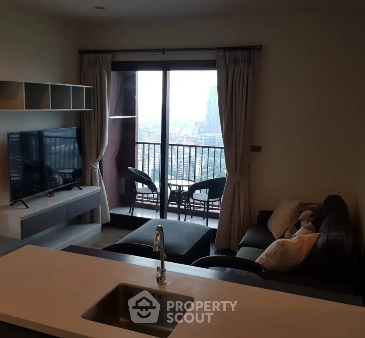 Modern living room with city view and balcony access in high-rise apartment
