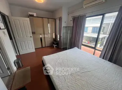 Spacious bedroom with large window and modern furnishings