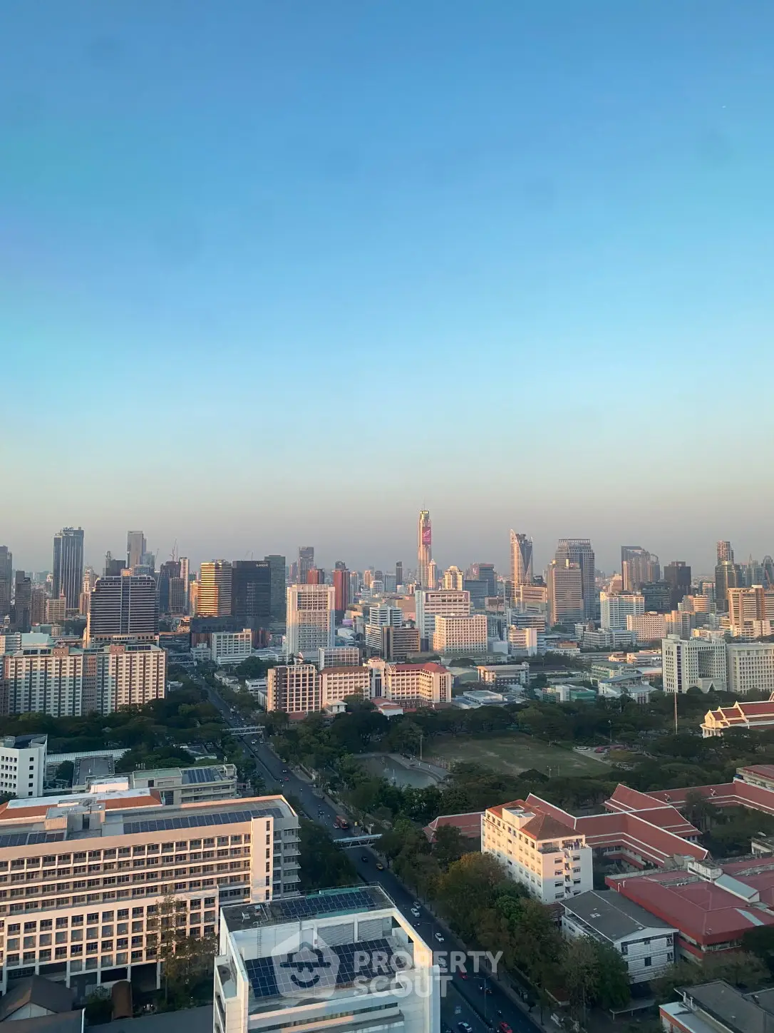Stunning cityscape view from a high-rise building showcasing urban skyline at sunset.