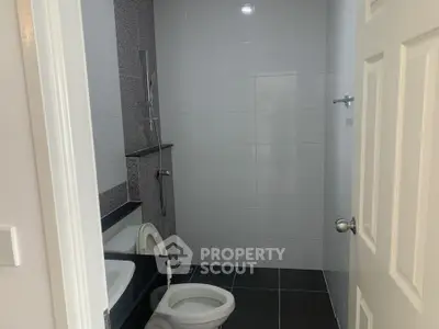 Modern bathroom with sleek black and white tiles and contemporary fixtures.