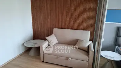 Modern living room with stylish beige sofa and wooden accent wall