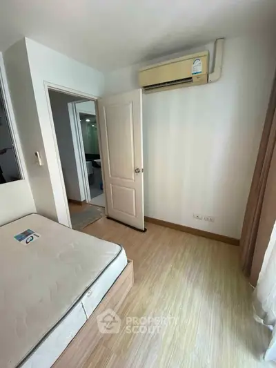 Cozy bedroom with air conditioning and wooden flooring, perfect for relaxation.