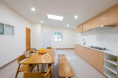 Spacious modern kitchen with wooden dining set and sleek cabinetry