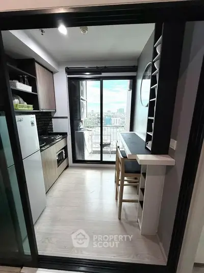 Modern kitchen with open layout and balcony view in urban apartment