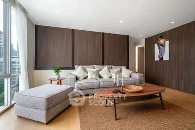 Modern living room with stylish furniture and large windows offering city views.